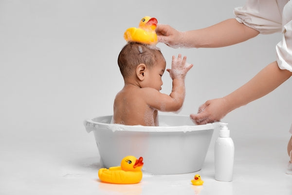 baby sitting in bath having hair washed