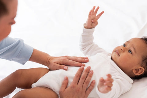 mother massaging baby's tummy