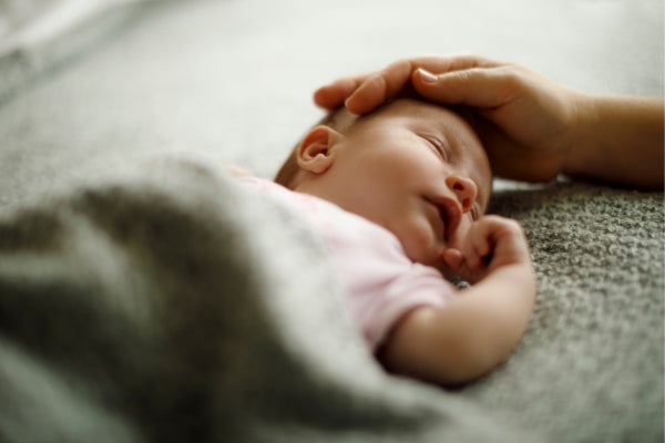 Sleeping baby with moms touch