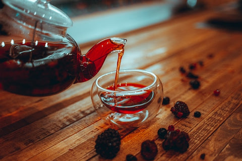 clear-glass-teapot-with-red-liquid-on-brown-wooden-table