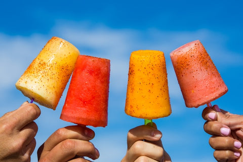 person-holding-orange-ice-pop