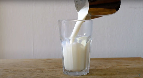 Die frisch zubereitete aufgeschäumte Milch in ein vorgewärmtes Glas geben