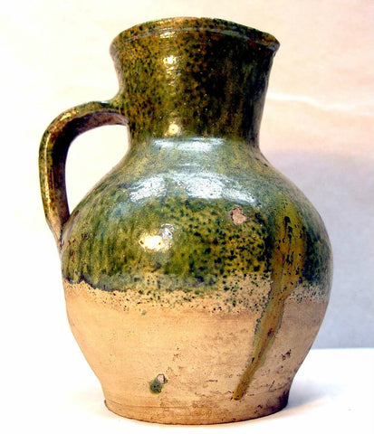 Late medieval Tudor Green ware jug, Buff fabric with yellow-green glaze on upper body; tall neck & rounded body with flat base & strap handle. source