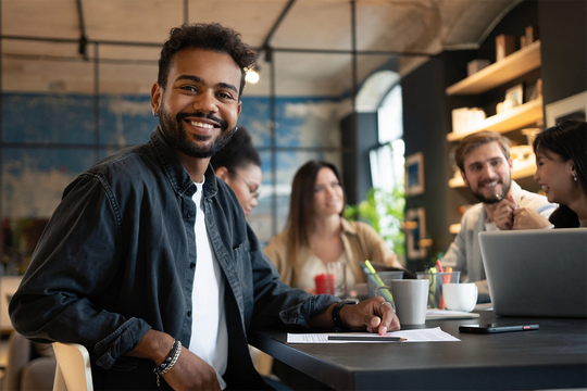 Young black male in modern office working with colleages