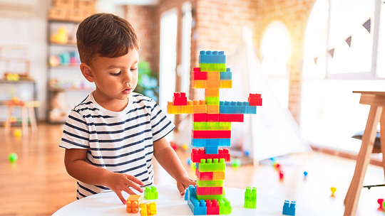 Young child playing with building blocks on a table