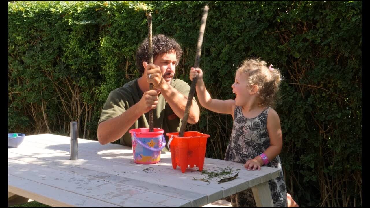 Father and daughter playing with sticks.