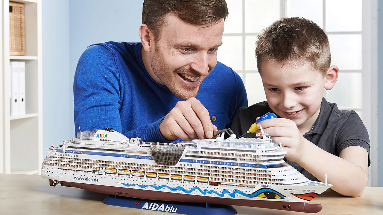 Father and son building a model kit of a cruise ship.