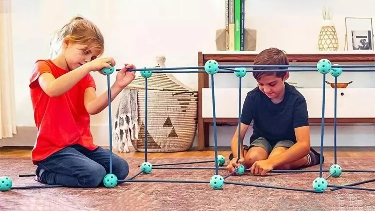 Kids building a fort with a fort-building kit.