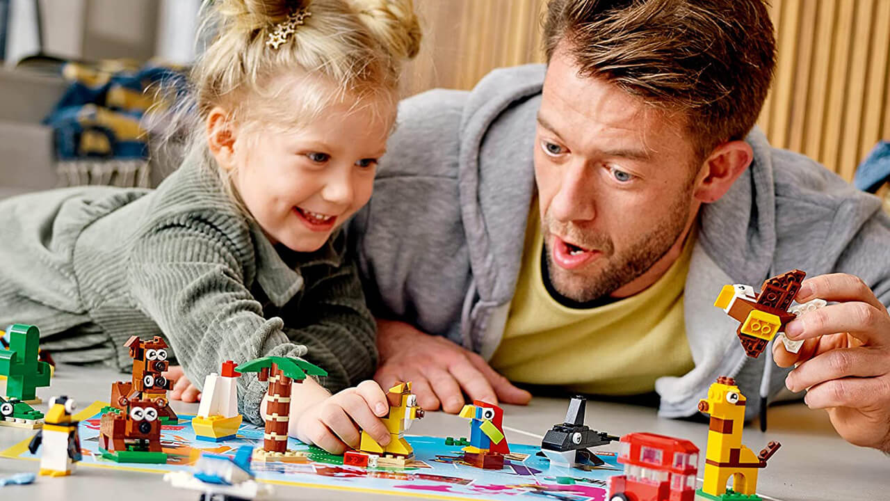 Father and daughter playing with a LEGO building set.