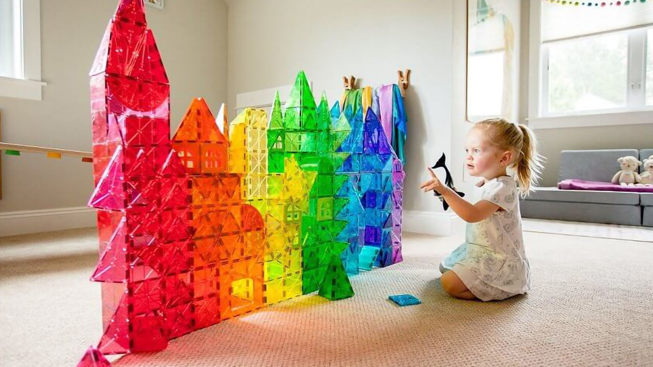 Girl playing with Magna-Tiles and building a castle.