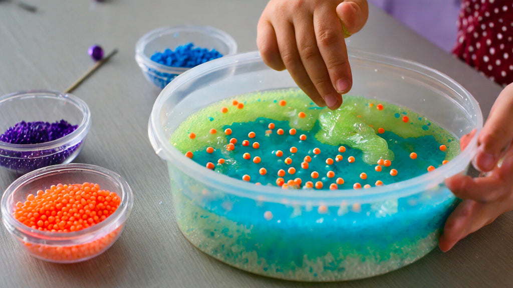 Someone making tactile slime with beads.