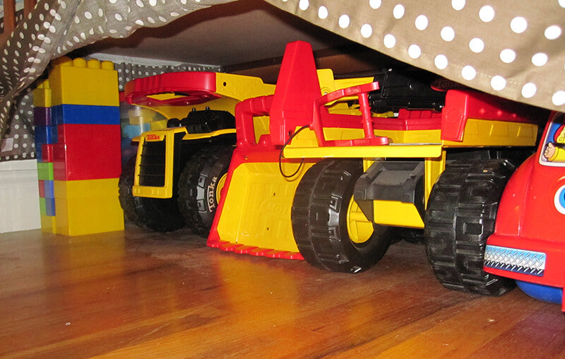 Toy trucks stored under the bed.