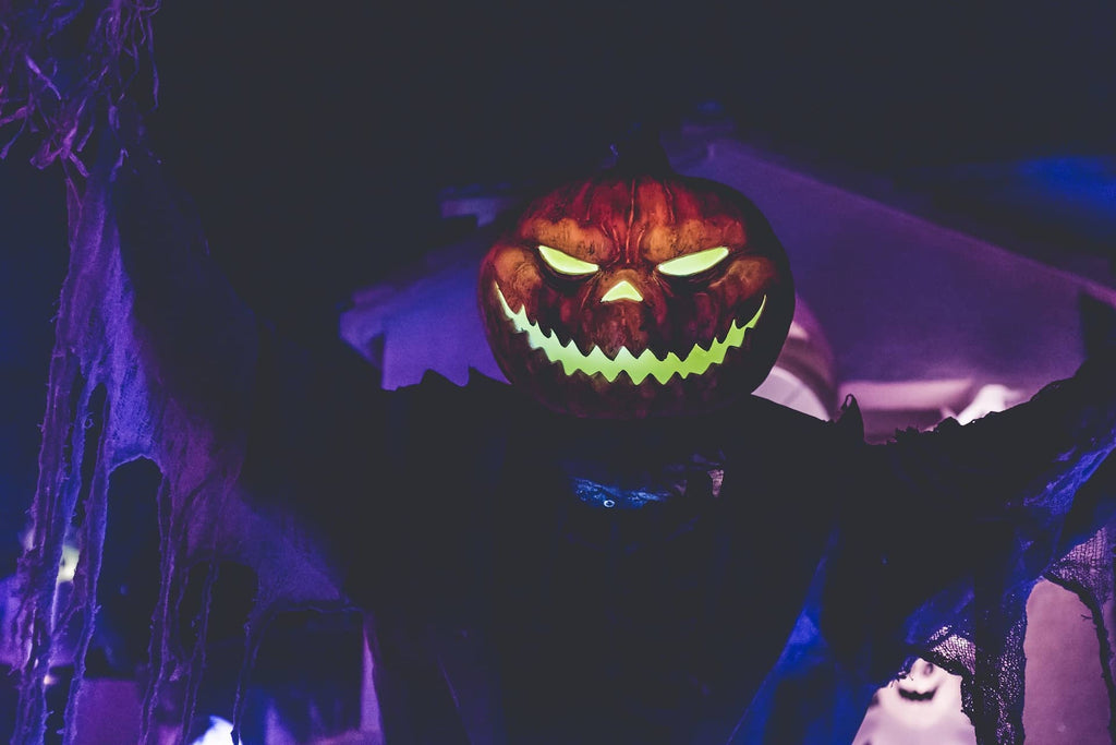 A jack-o'-lantern decoration in a house lit by black lights