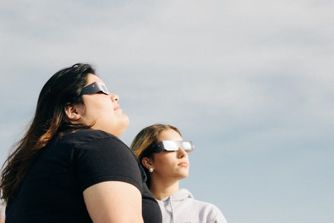 Two people viewing the sky with eclipse glasses
