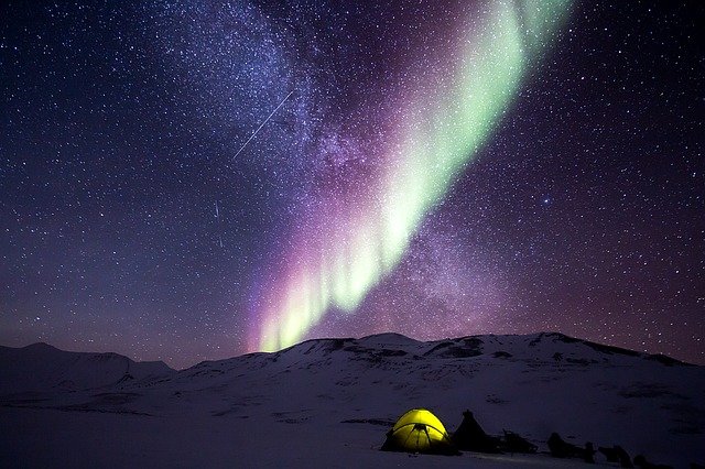 campers near snowy mountain at nigh