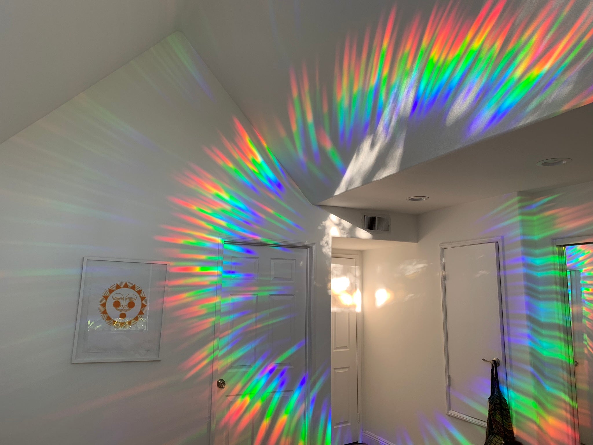 A room with rainbows on the wall made by rainbow suncatcher stickers