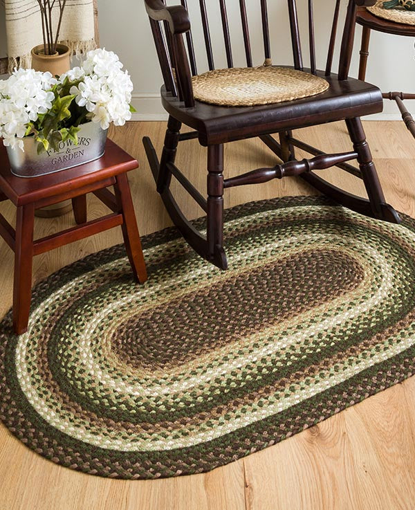 Dark brown, green and tan braided rug under rocking chair made from organic jute.