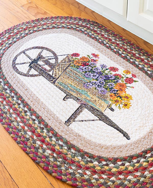 Braided rug with farmhouse style wheelbarrow full of flowers
