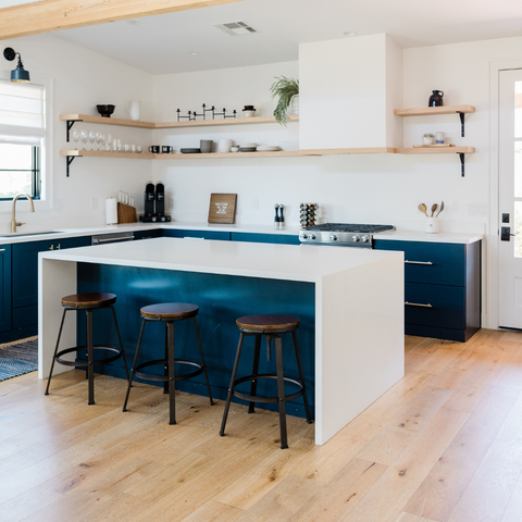 a kitchen with blue cabinets and wooden floors