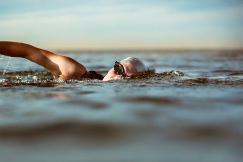 Ocean swimmer with goggles and a swim cap swimming in the ocean