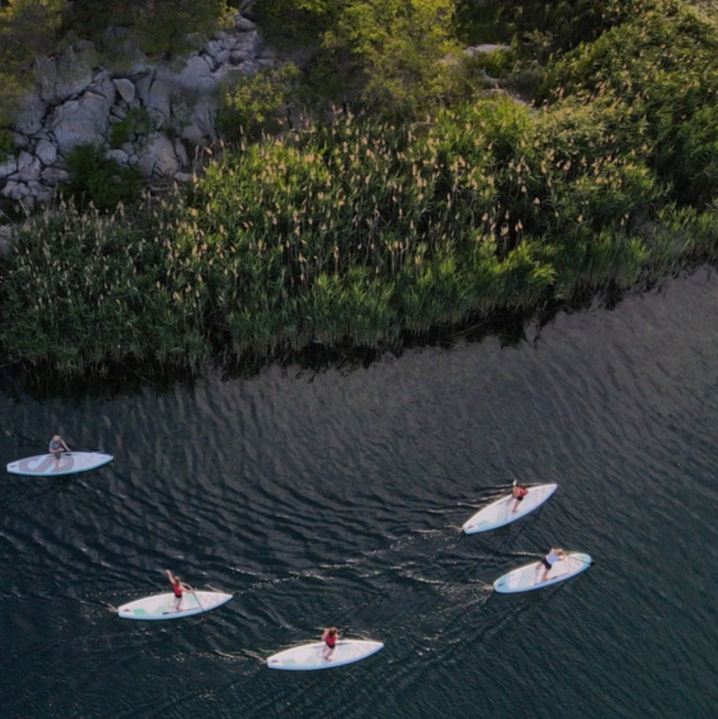 A group of SipaBoards Drive Neo Silver Motorized SUP going down a river.