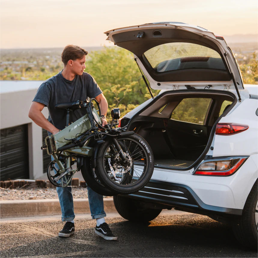 Folded Lectric XP4 being loaded into the back of a SUV.