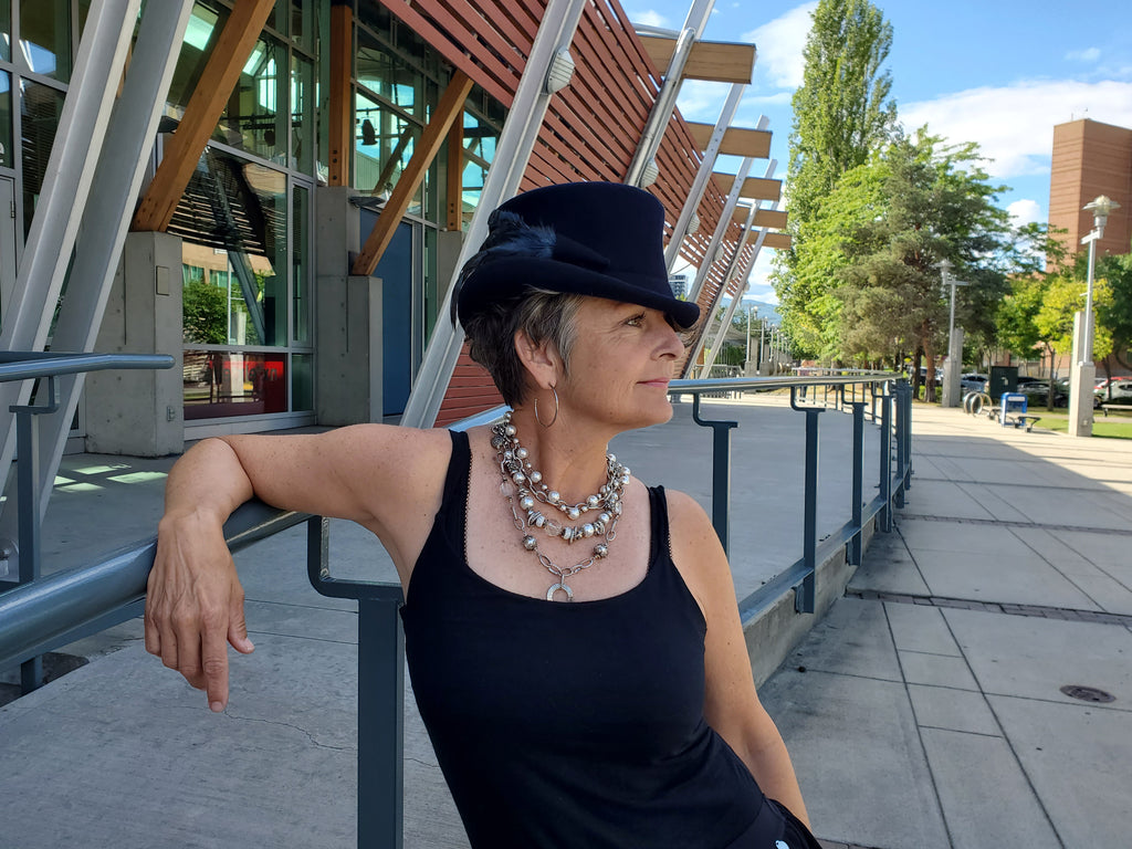Woman wearing a Canadian made necklace and black hat