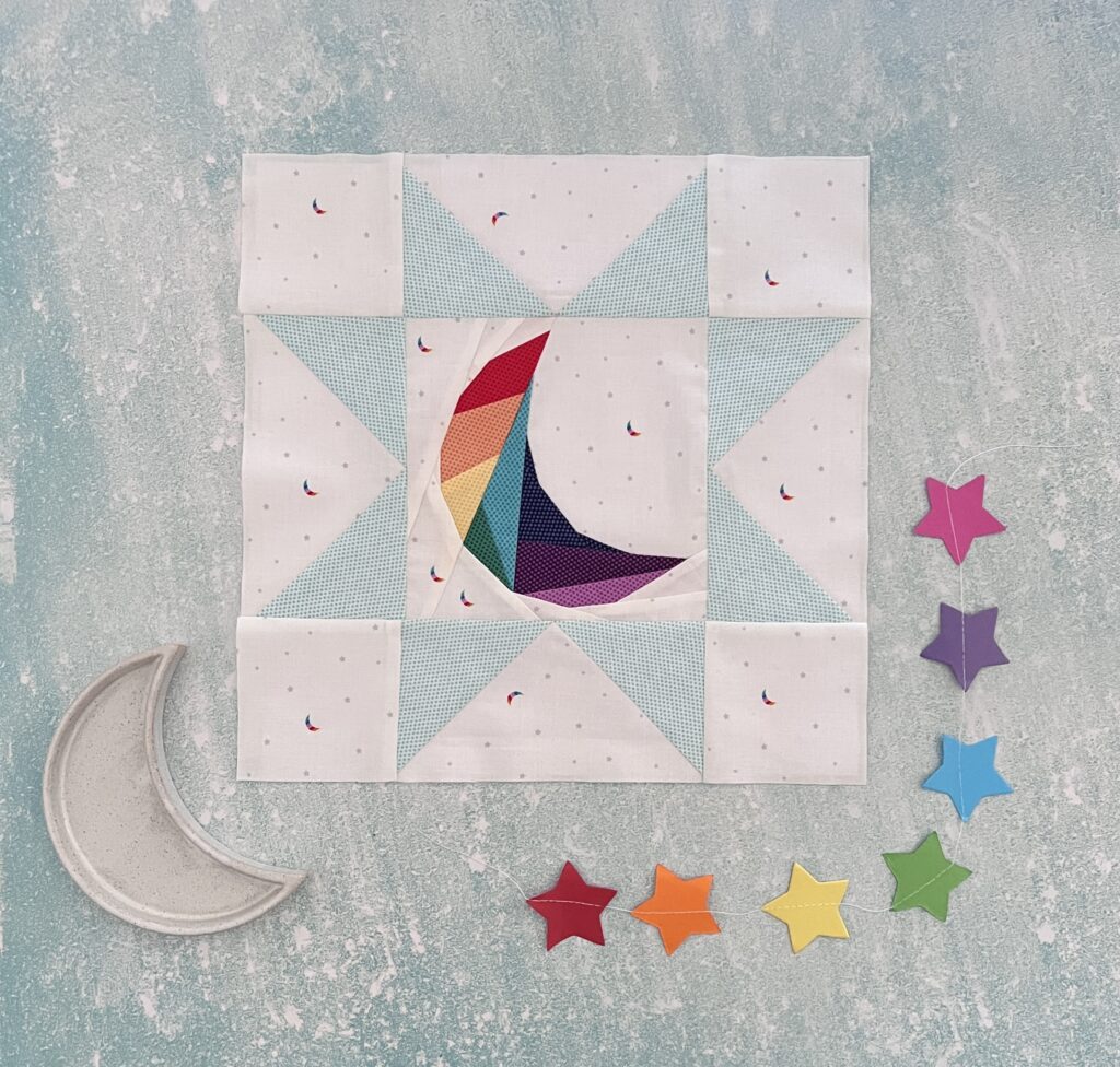 Geometric moon pattern in a foundation paper pieced block using a rainbow of colours and prints from Hush Hush vol 3