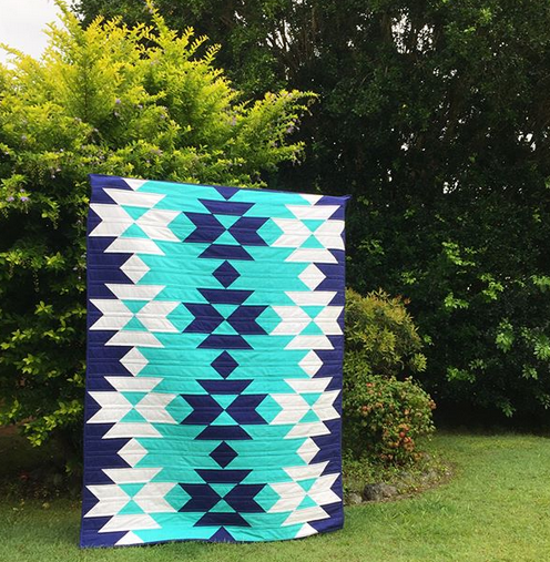 Squash Blossom block made into a quilt using three solid colours