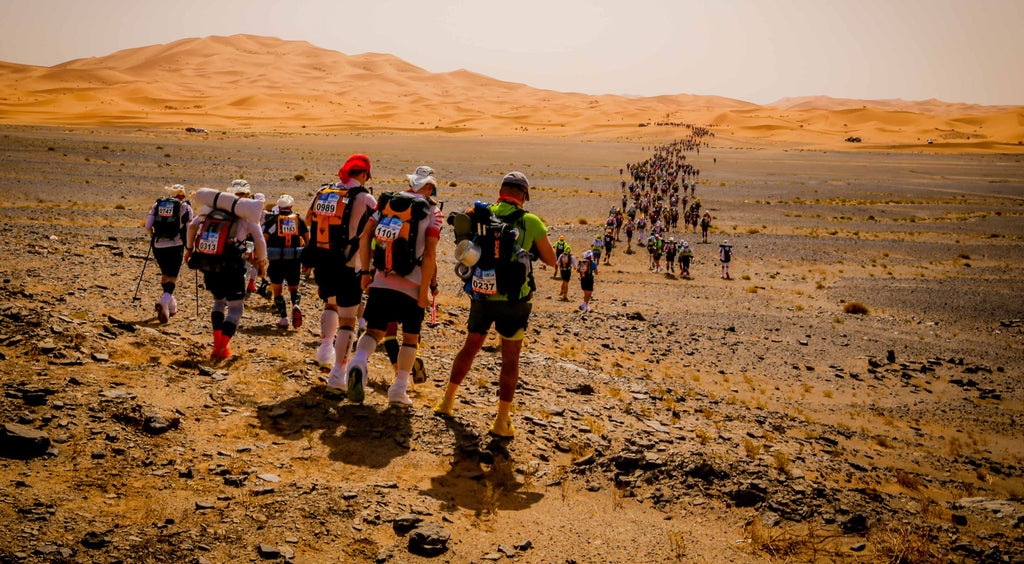 MdS runners in the desert descending a hill