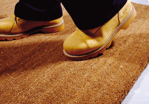 Coir matting being walked over with muddy boots