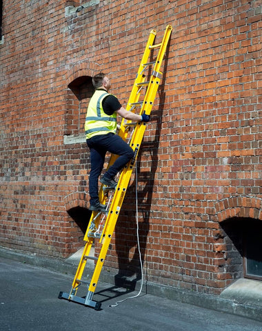 Two ladders are leaning against a wall in such a way that they