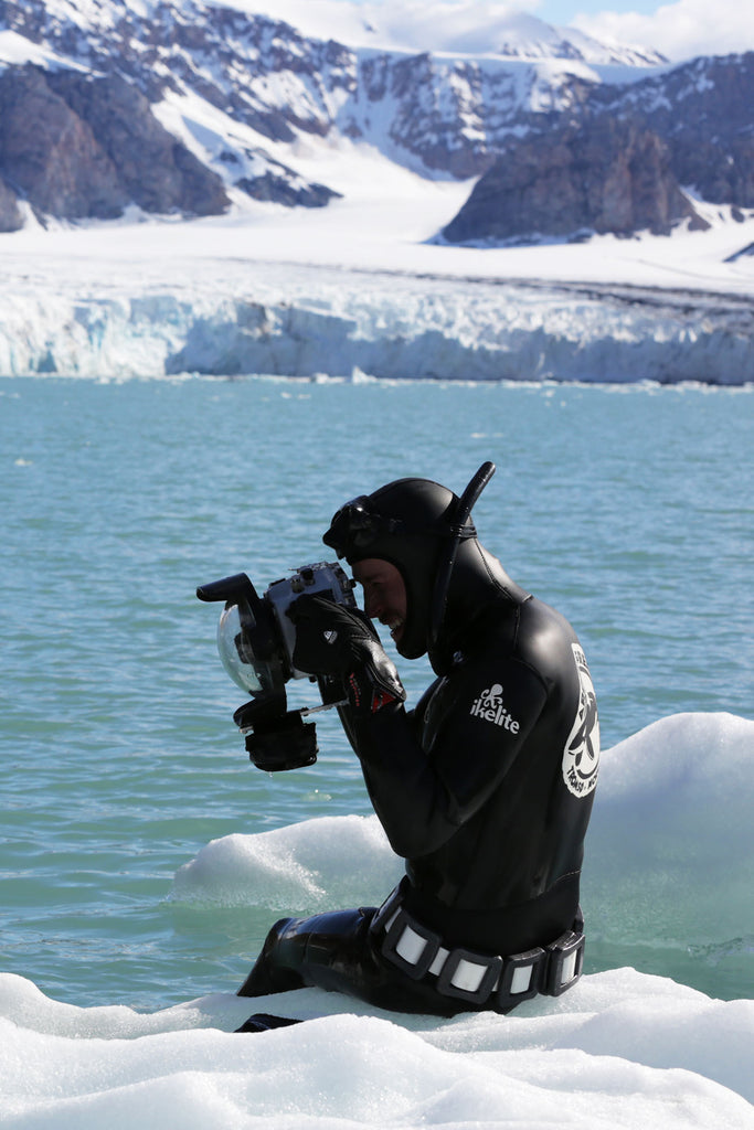 ikelite ambassador jacque de vos looks through his ikelite underwater housing while sitting on an ice cap