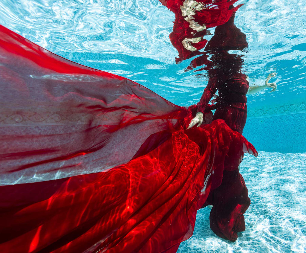 red dress with sunlight reflection patterns underwater pool photoshoot using an ikelite housing and strobes