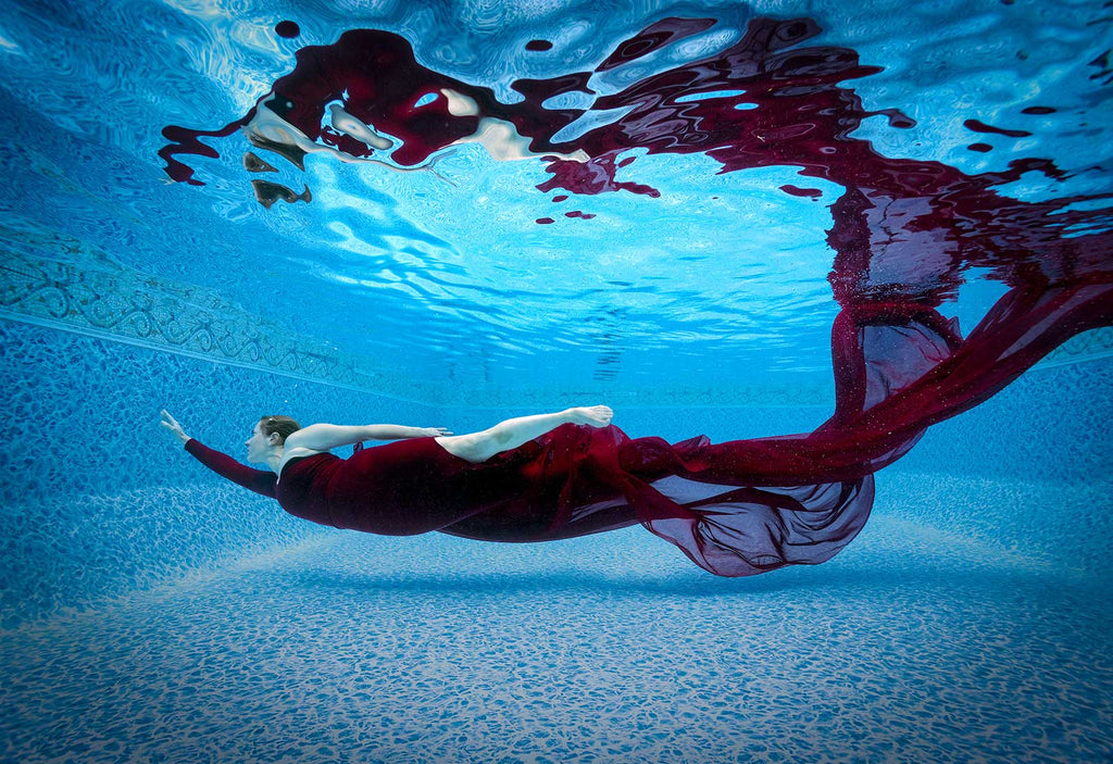 Jean Rydberg swims with a long red dress in an underwater pool photoshoot using ikelite housing and strobes