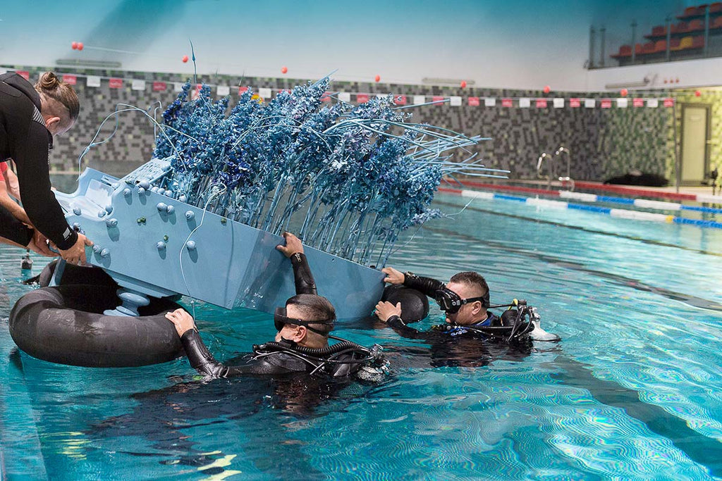 piano being sunk into a pool for photoshoot by rafal makiela using an ikelite underwater housing