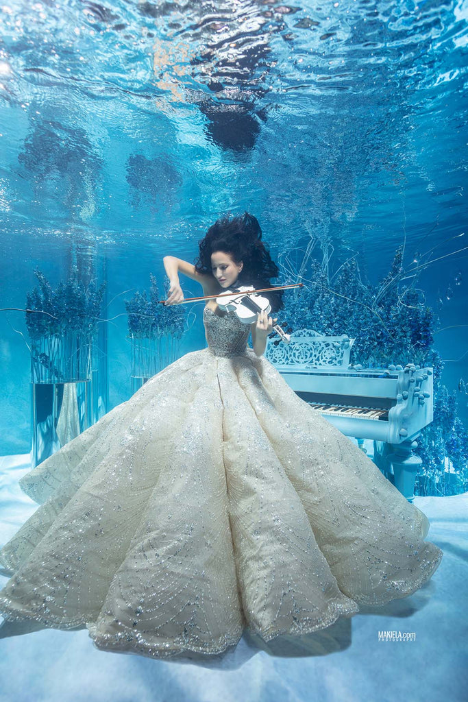 Justyna Steczkowska with a violin and piano underwater for rafal makiela photo shoot using an ikelite underwater housing