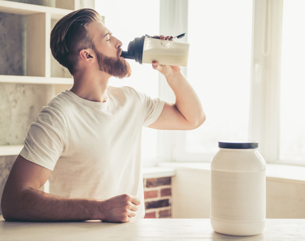  Bearded man drinking protein shake with added supplements