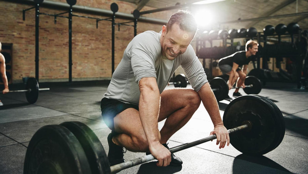 Man smiling while preparing to lift weights