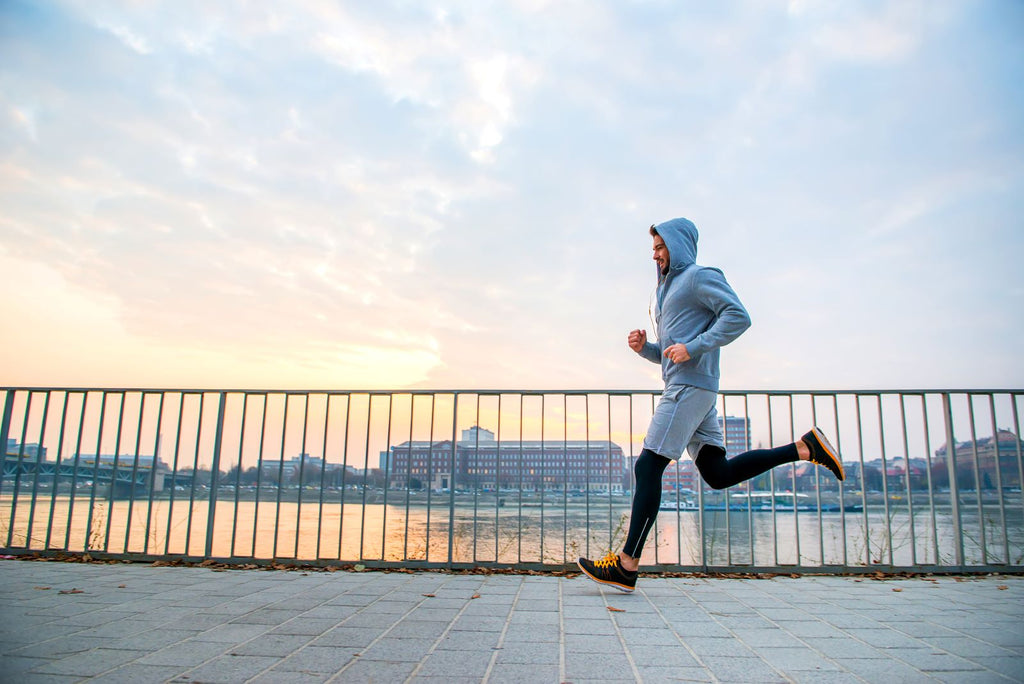 Man running down sidewalk at sunrise