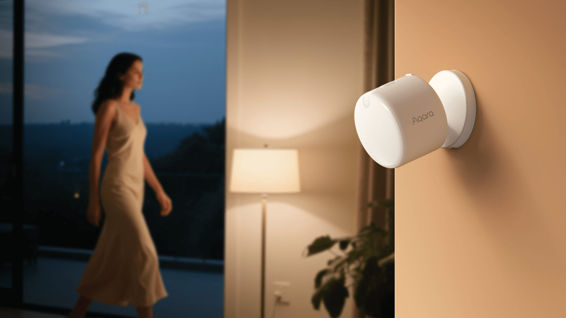A woman in a white dress walks past the living room's floor-to-ceiling windows; an FP300 is installed on a nearby wall.