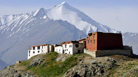 Rangdum Monastery on hilltop with snow covered mountains in background