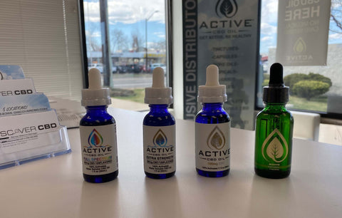 Three different types of CBD tincture sitting on a counter in the Discover CBD Store