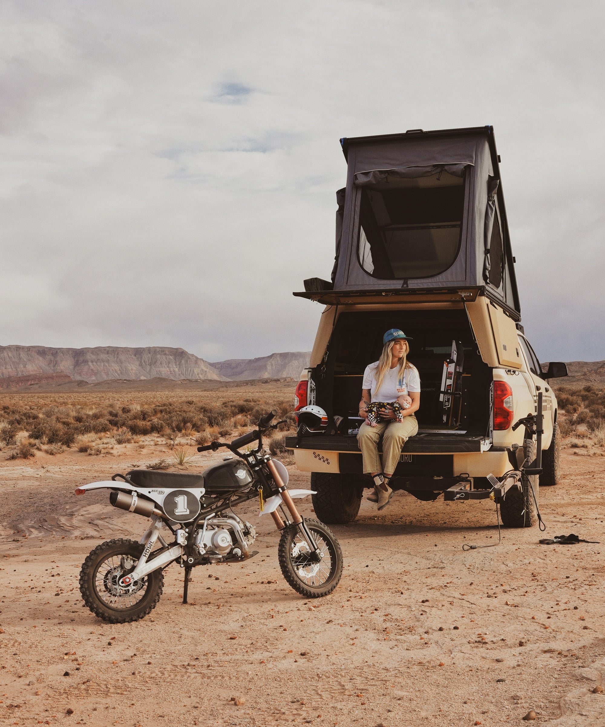 Toyota Tundra with a Super Pacific X1 truck camper buildout, parked in the Utah desert next to a Buscadero Pit Bike..