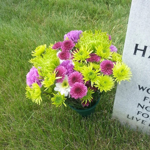 A bouquet of flowers next to a headstone