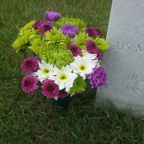 A bouquet of flowers next to a headstone