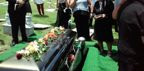 Funeral attendees gathering near a casket 