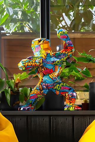 a multi coloured pop art gorilla sculpture in a brightly coloured home with plants