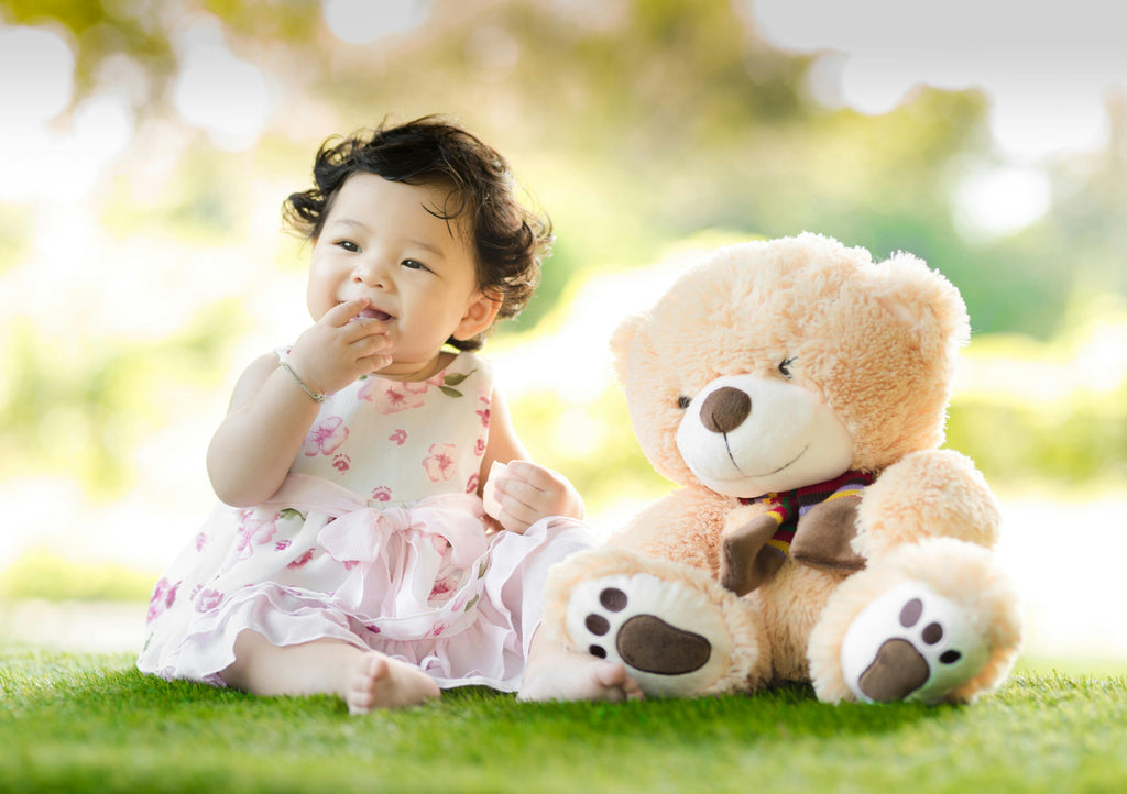 Cute Little Girl with Stuffed Bear Plushie on Lawn
