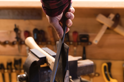Filing hatchet to sharpen